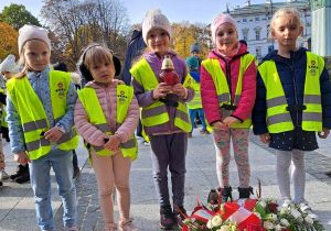 Dzieci palą znicze pod pomnikiem Powstania Warszawskiego