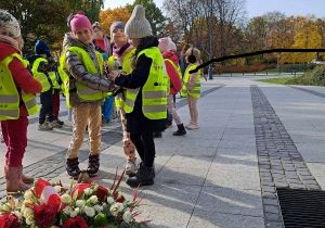 Dzieci stawiają znicze pod Pomnikiem Powstania Warszawskiego