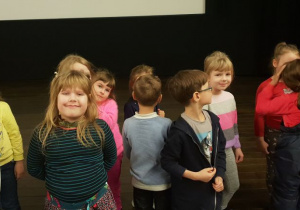 Dzieci stojące przed ekranem kinowym.