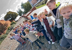 Starszaki stoją w grupie na Starym Mieście i pozują do zdjęcia
