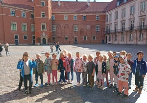 Dzieci spacerują w grupie po Placu Zamkowym