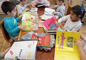 Dzieci oglądają książki w bibliotece