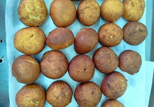 Pączki przygotowane do posypania cukrem pudrem.