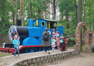 Przedszkolaki zwiedzają niebieską lokomotywę.